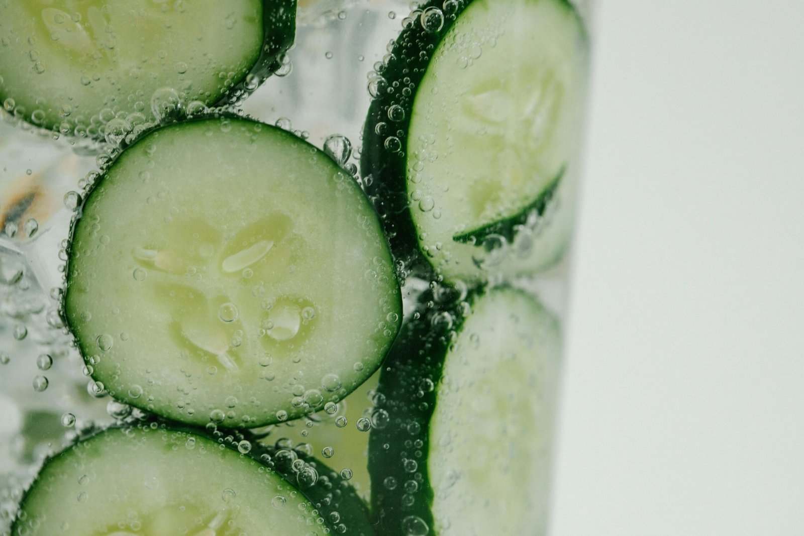 Rodajas de pepino en agua con gas, ilustrando una bebida refrescante rica en minerales beneficiosos para el organismo